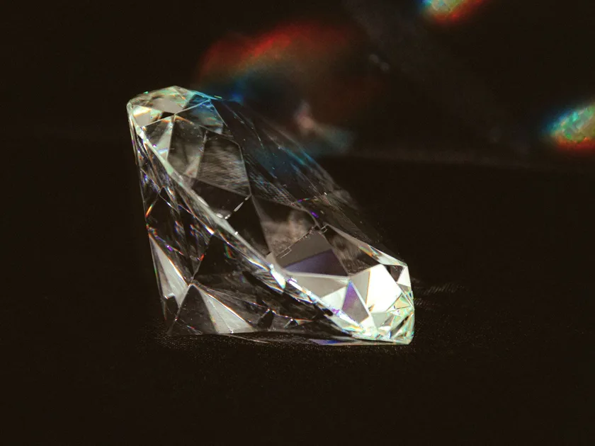 A loose brilliant cut diamond on a dark ground