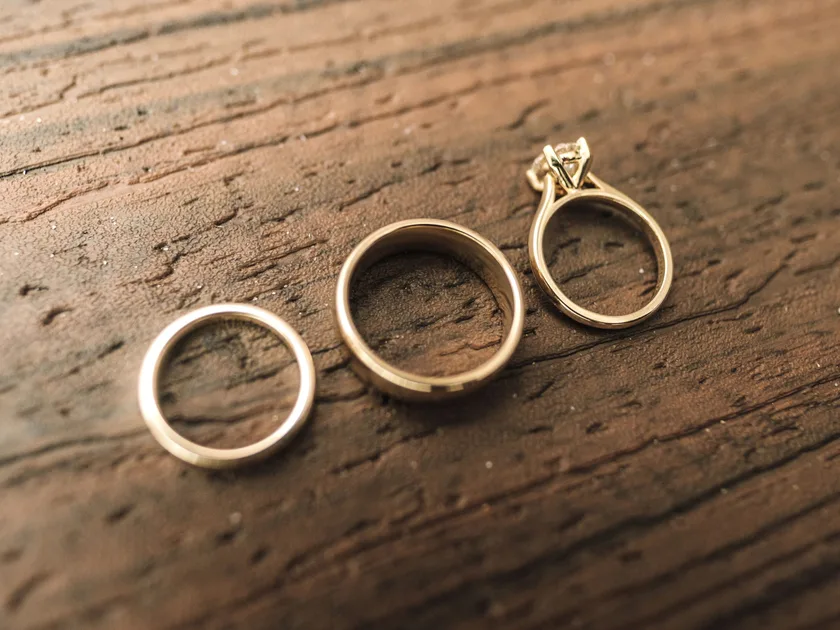 Three gold rings on dark wood