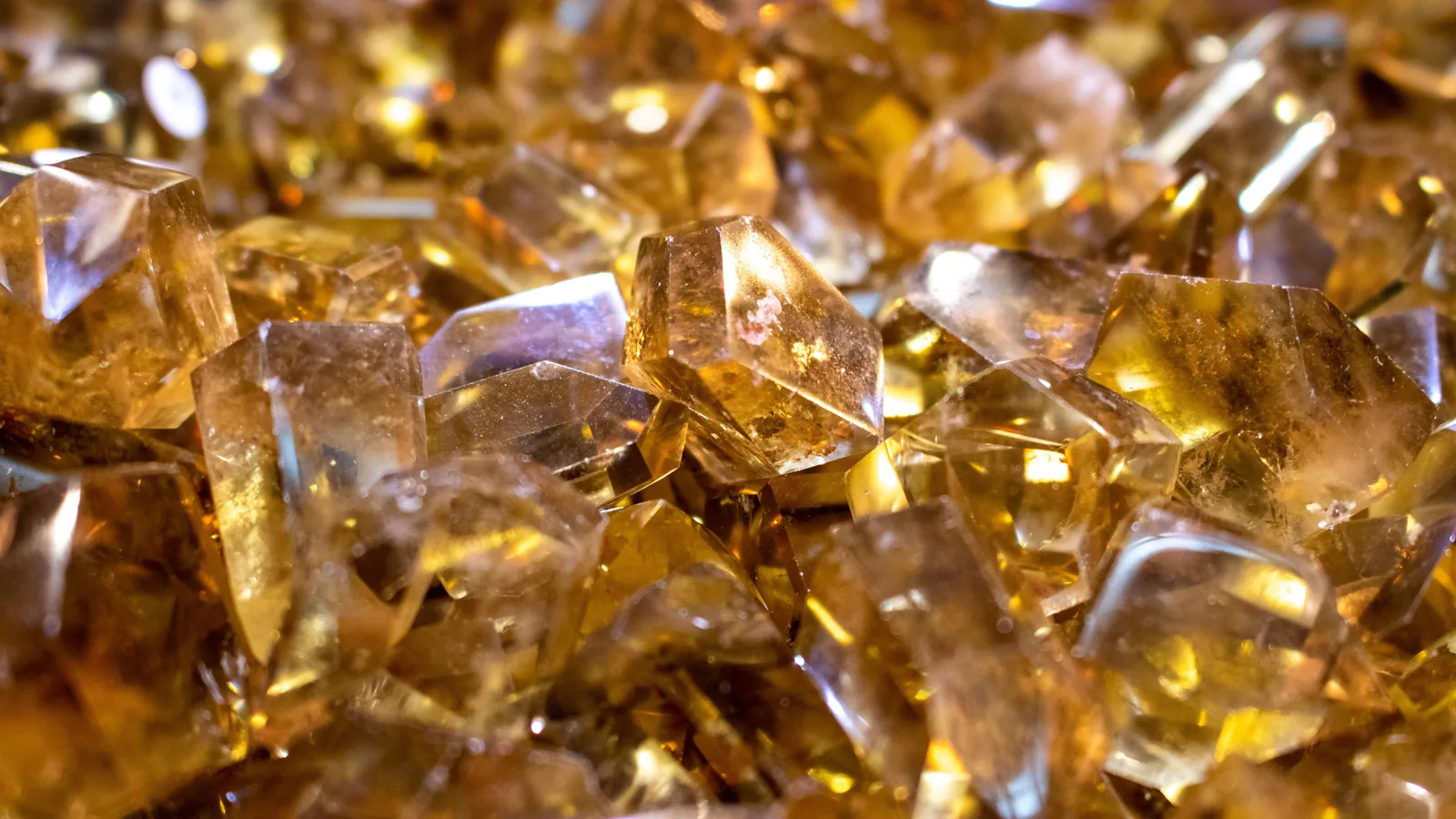 A close-up of loose golden gemstones catching the light