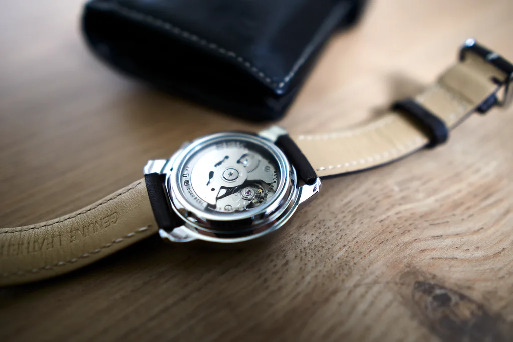 Macro photograph of a mechanical watch seen through an exhibition case back, movement visible