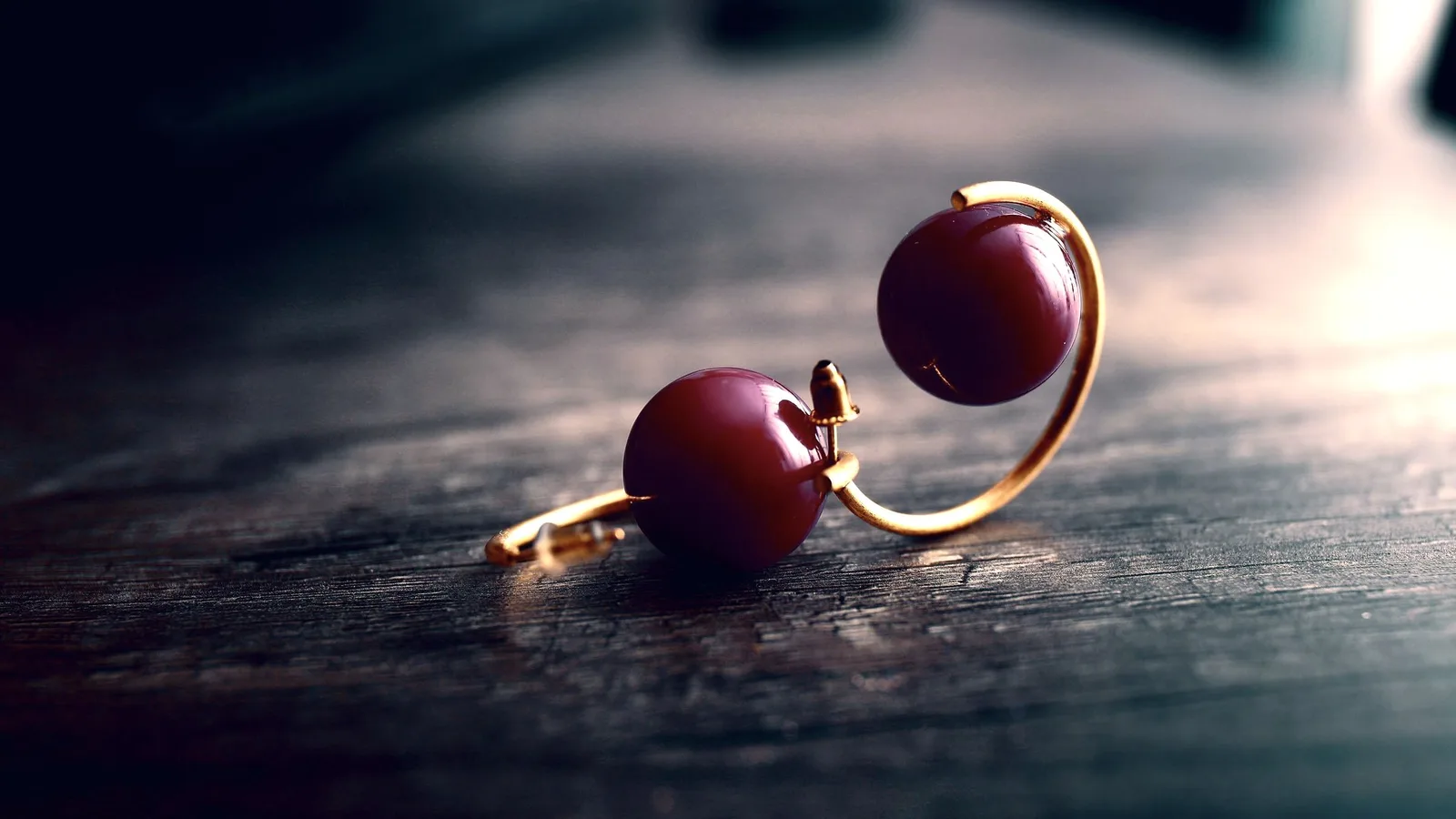 A single diamond stud earring resting on a dark surface