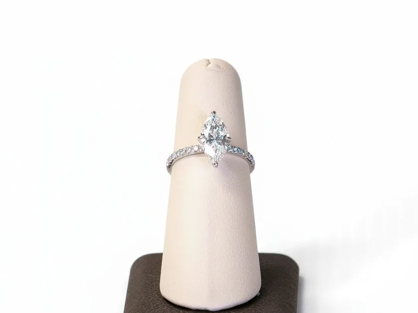 A marquise cut diamond solitaire on a display cone, prongs visible at the stone