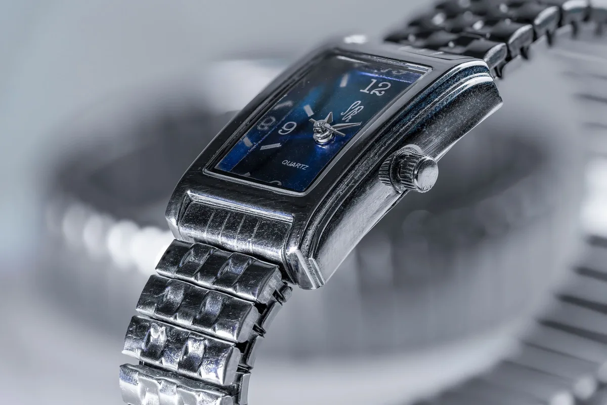 A silver quartz wristwatch with a deep blue dial and steel bracelet