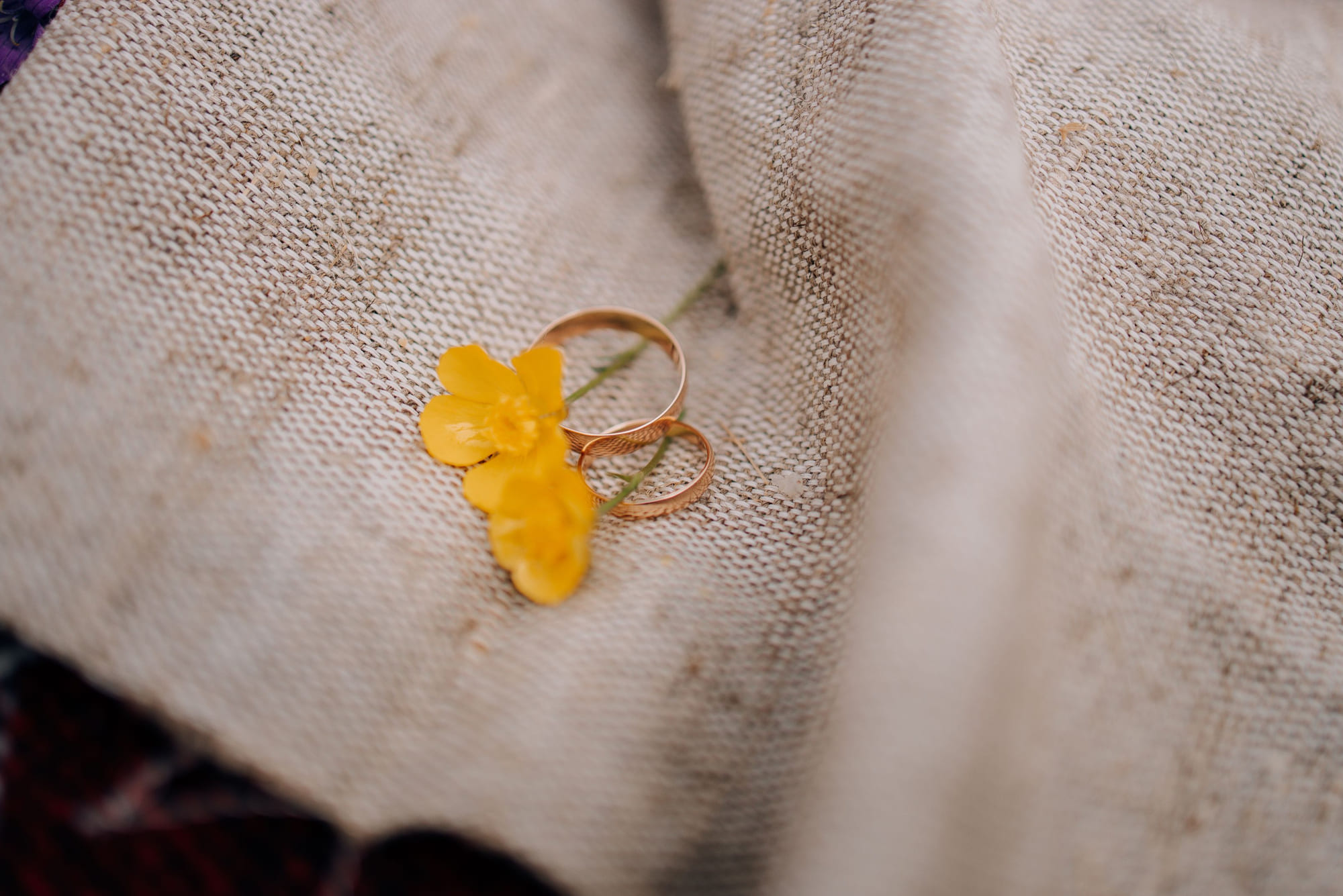 Two worn gold wedding bands resting on homespun linen