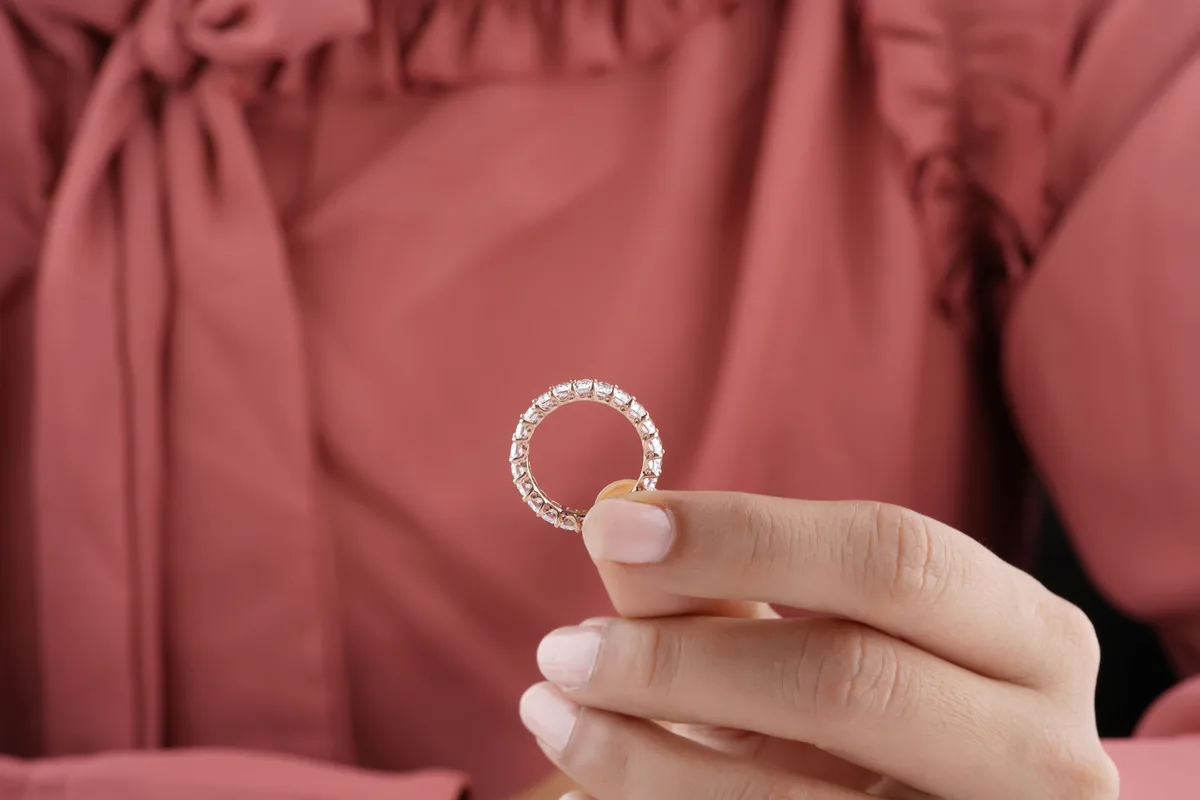 An eternity band set with diamonds all the way around, held up